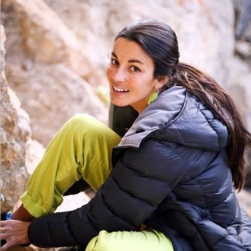 Daila Ojeda, pro climber on the Rockbusters team, smiling at the crag